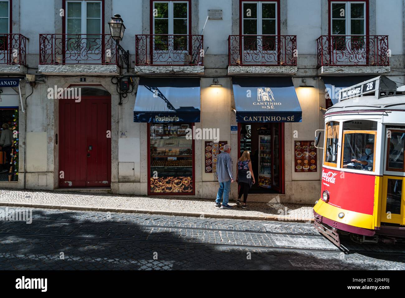 I famosi tram di Lisbona mentre si spostano attraverso la vecchia strada di Lisbona Foto Stock