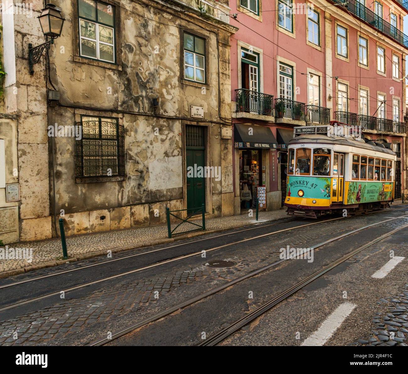 I famosi tram di Lisbona mentre si spostano attraverso la vecchia strada di Lisbona Foto Stock
