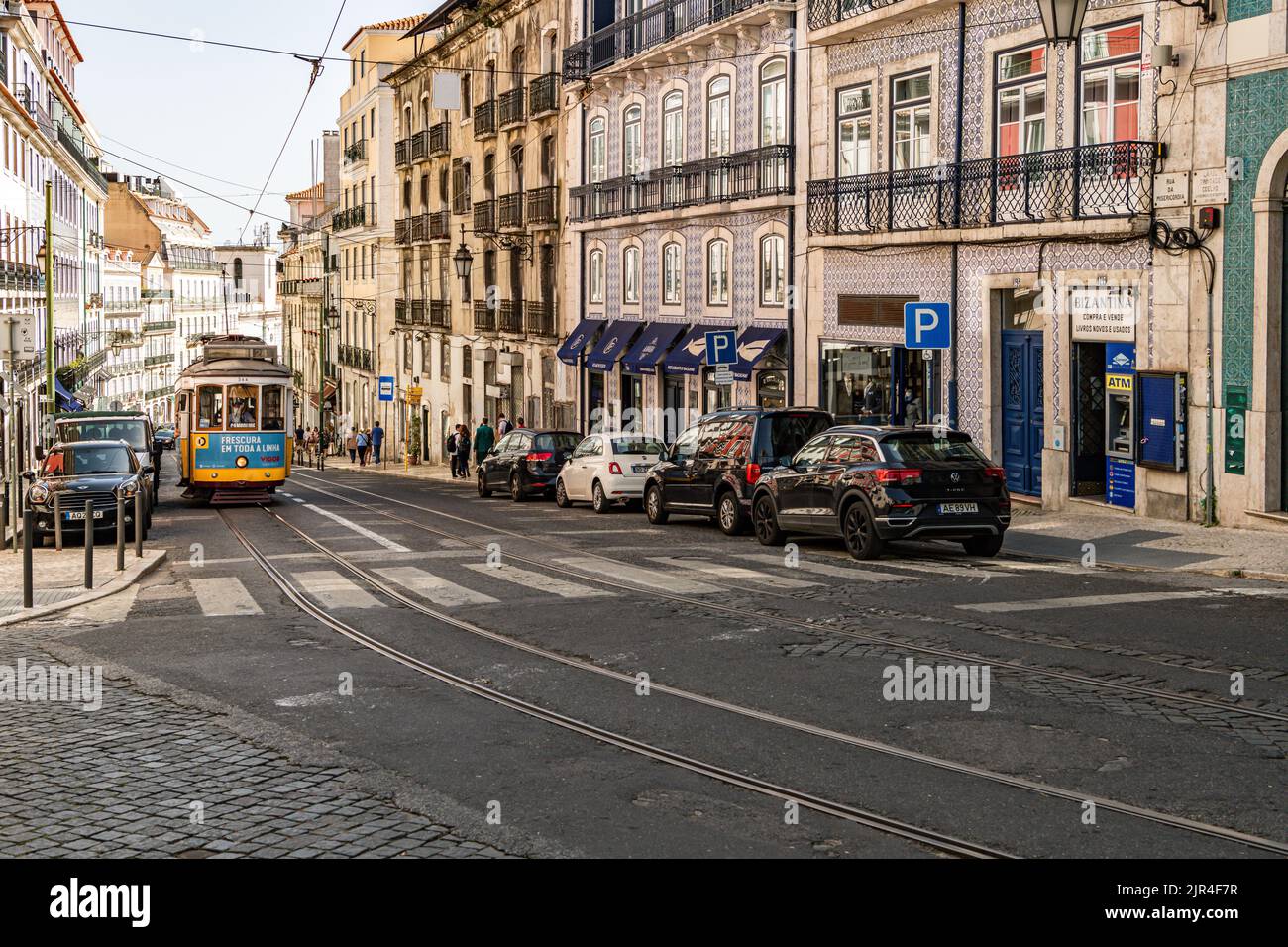 I famosi tram di Lisbona mentre si spostano attraverso la vecchia strada di Lisbona Foto Stock