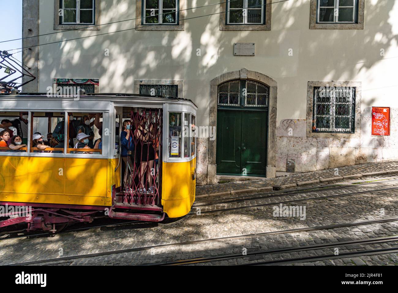I famosi tram di Lisbona mentre si spostano attraverso la vecchia strada di Lisbona Foto Stock