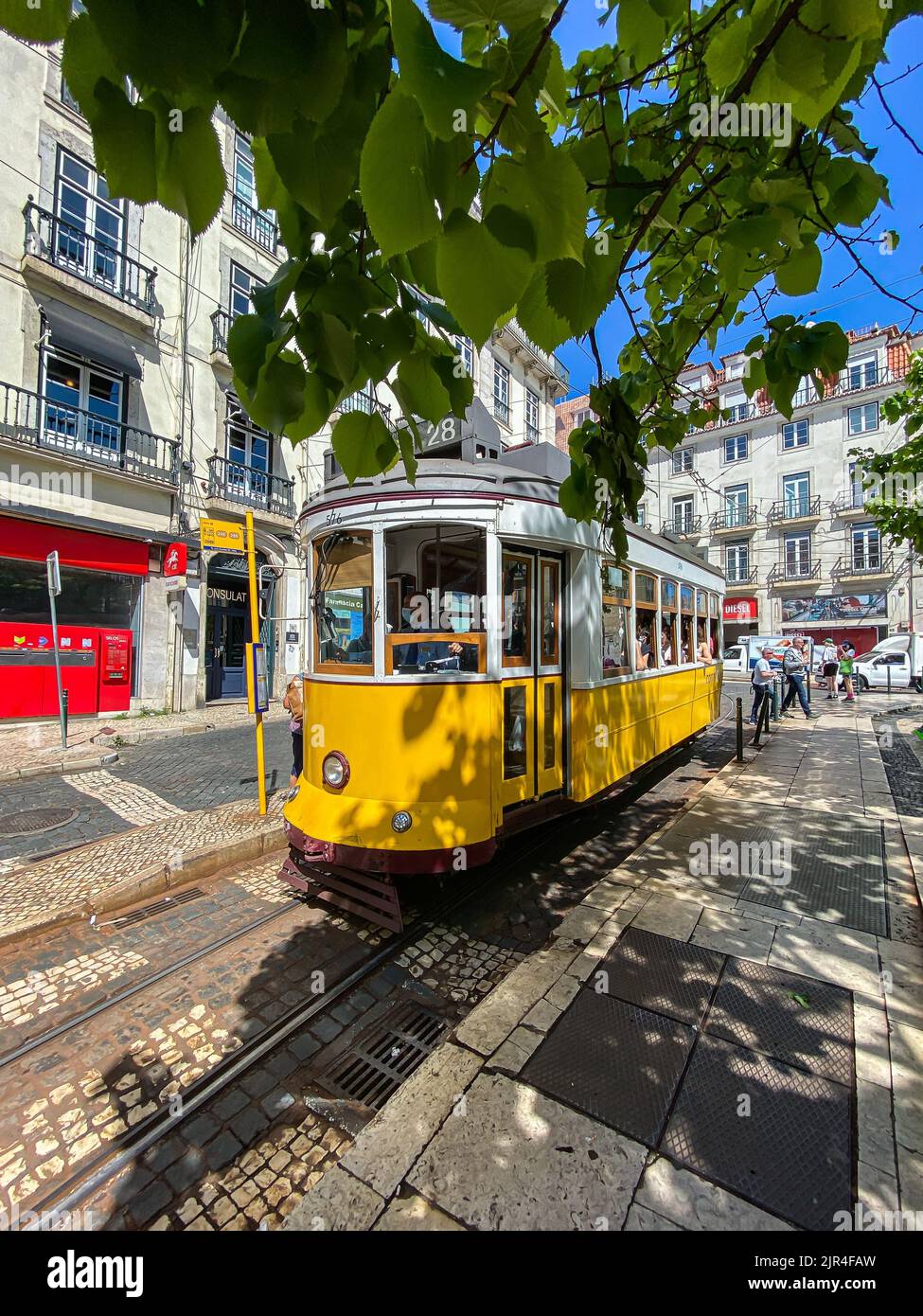 I famosi tram di Lisbona mentre si spostano attraverso la vecchia strada di Lisbona Foto Stock