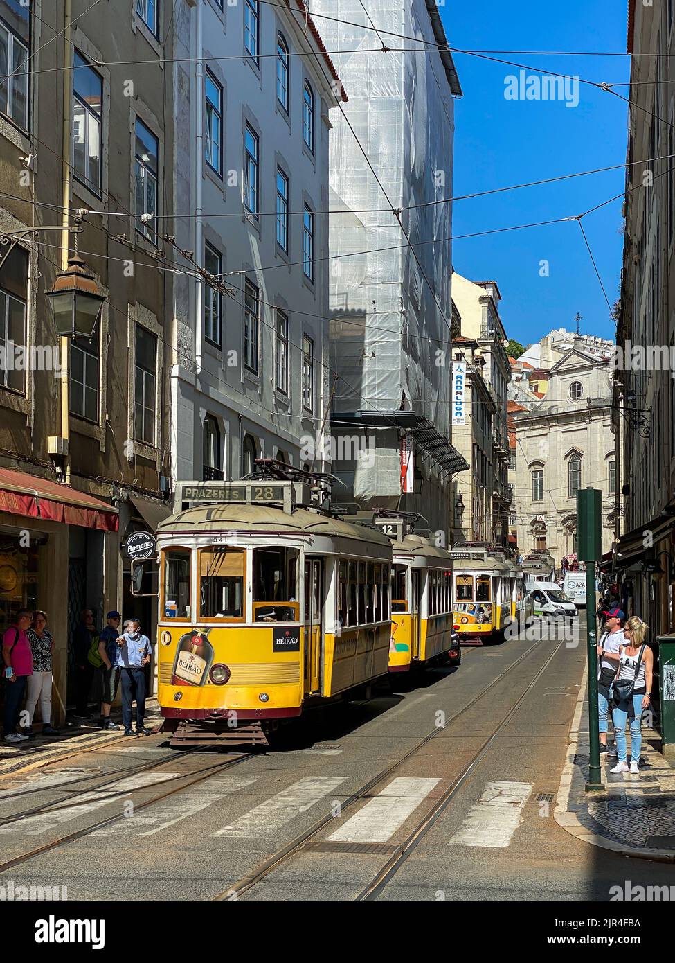 I famosi tram di Lisbona mentre si spostano attraverso la vecchia strada di Lisbona Foto Stock