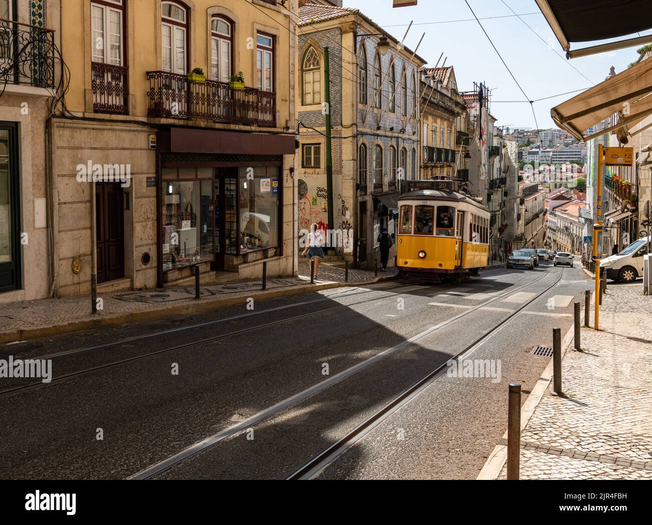 I famosi tram di Lisbona mentre si spostano attraverso la vecchia strada di Lisbona Foto Stock