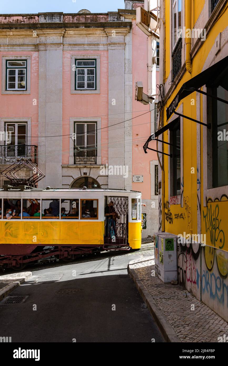 I famosi tram di Lisbona mentre si spostano attraverso la vecchia strada di Lisbona Foto Stock