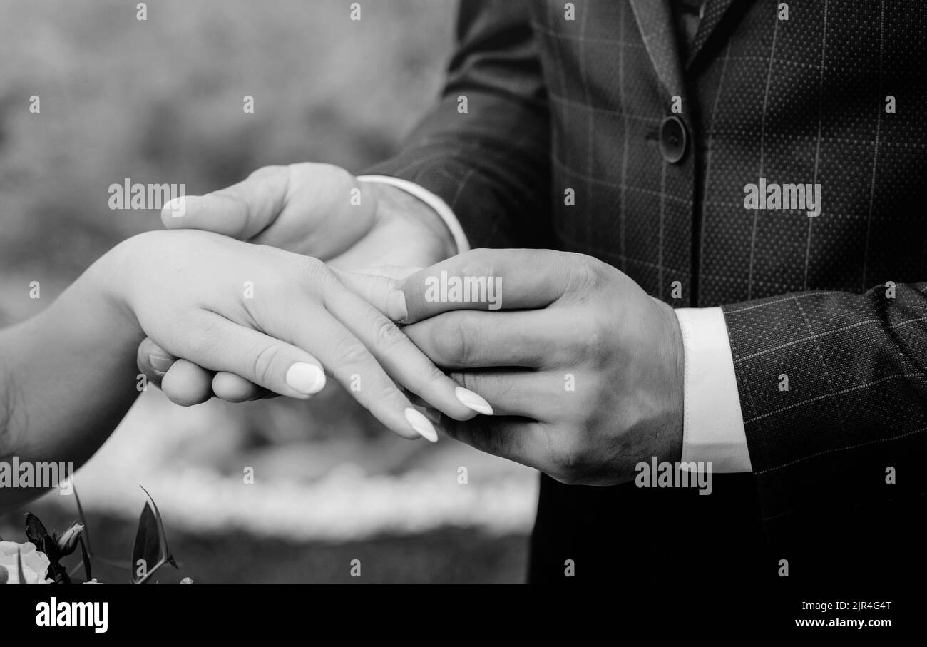 coppia scambiando gli anelli di nozze durante la loro cerimonia nuziale. sposi mettendo un anello di nozze sul dito della sposa. Foto Stock
