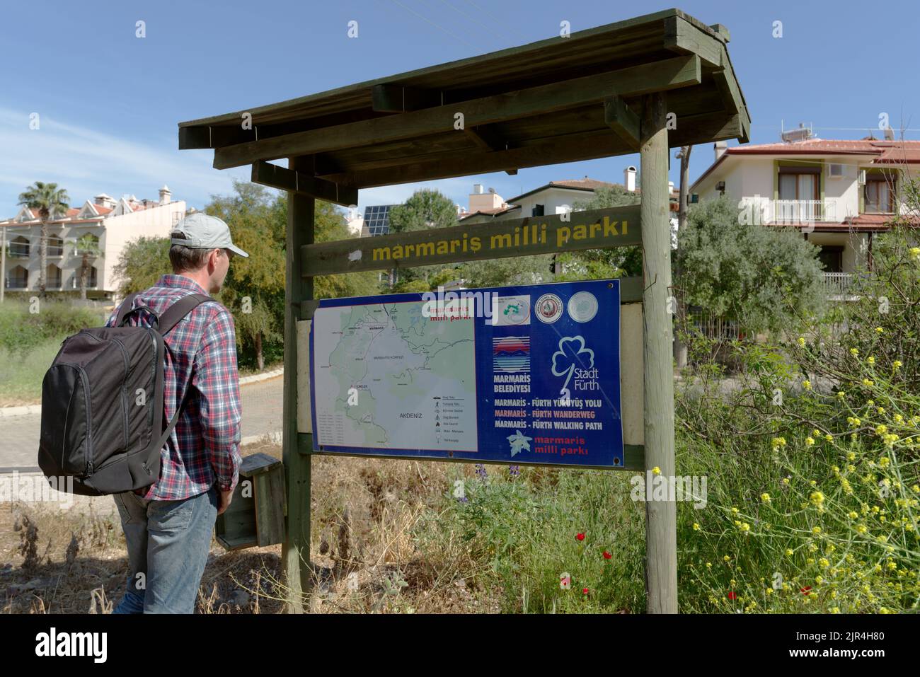 Turista con zaino alla mappa del Parco Nazionale Marmaris a Marmaris, Turchia Foto Stock