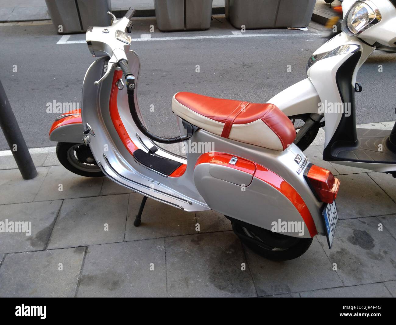 Un primo piano di un classico scooter Piaggio Vespa rosso sulla strada Foto Stock