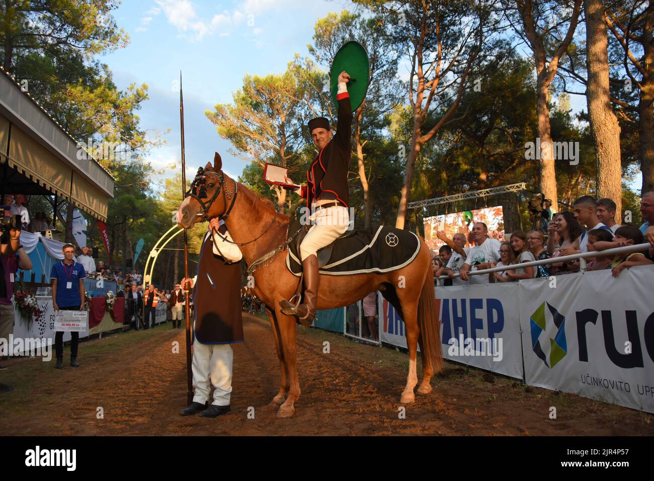 Barban, Croazia, 22 agosto 2022. Vincitore del torneo Race of the Ring, un cavaliere Petar Bencic posa per foto con uno scudo a Barban, Croazia, il 22 agosto 2022. La corsa dell'anello è un gioco del cavaliere in cui il cavaliere deve attraversare il percorso lungo 150 metri e con una lancia colpire l'anello costituito da due cerchi concentrici interconnessi in modo che ci siano quattro campi tra loro. Il primo record della gara sul ring risale al 1696. A quel tempo fu organizzato dalla famiglia loredana veneziana durante le fiere del villaggio di Barban in Istria, e i concorrenti erano mo Foto Stock