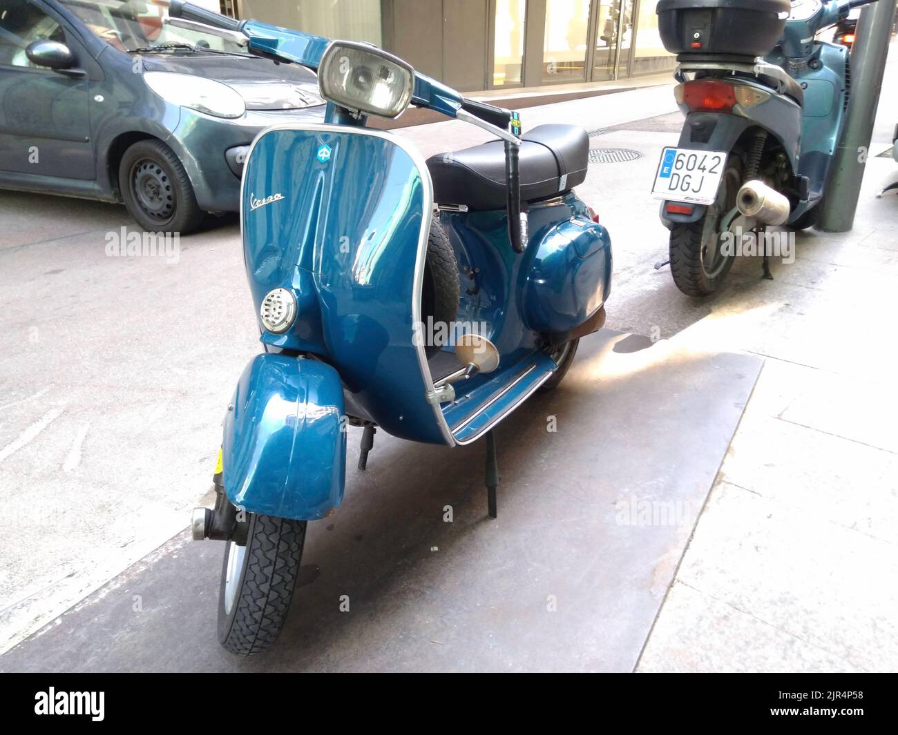 Un primo piano di uno scooter Piaggio Vespa classico blu sulla strada Foto Stock