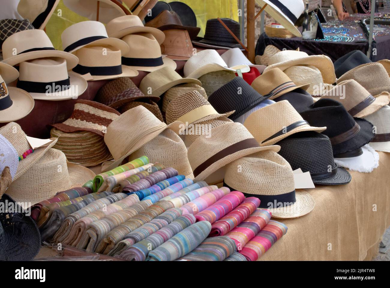 Un mercato in stallo Pollenca Mallorca Spagna Vendita di cappelli di paglia e a strisce colorate sciarpe Foto Stock