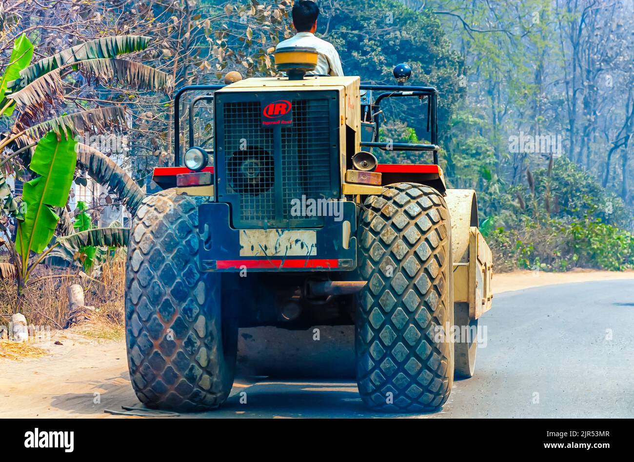 Un rullo vibrante / compattatore Ingersoll-Rand SD 100D che striscia a passo di lumaca su un'autostrada in India. Foto Stock
