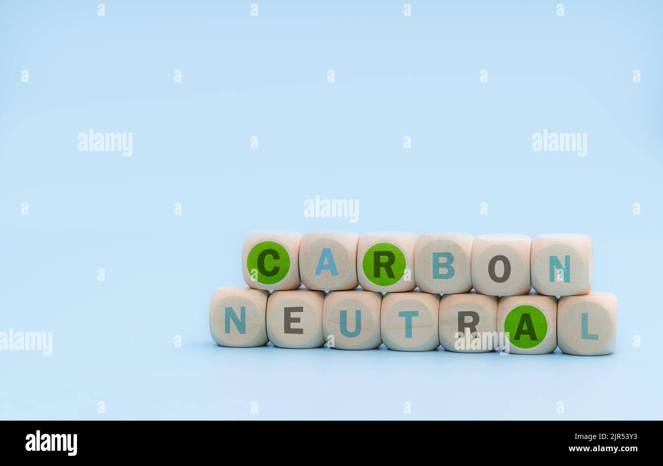 Concetto di carbonio neutro. Cubi di legno con parole neutre al carbonio su sfondo blu. CO2 banner Web neutro. Business aziendale a lungo termine, neutrale dal punto di vista del carbonio Foto Stock