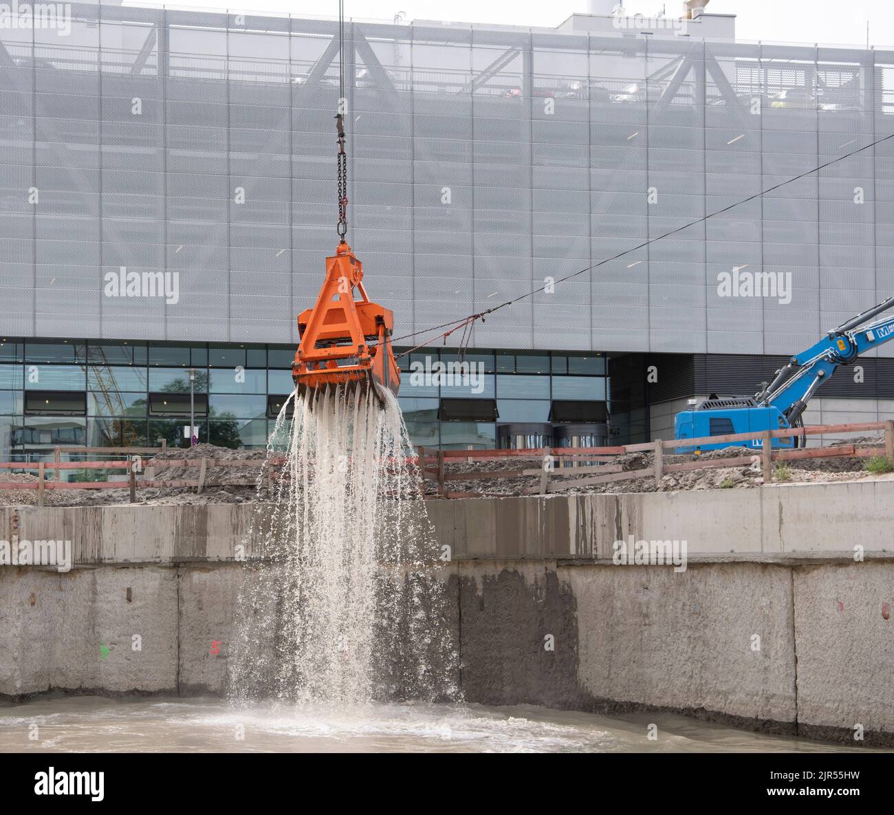 Berlino, Germania. 22nd ago, 2022. Un escavatore solleva i fanghi dal nuovo canale del serbatoio in costruzione a Chausseestraße a Mitte. Berliner Wasserbetriebe ha presentato la struttura ad un evento stampa. Il nuovo bacino conserverà fino a 16.750 m³ di acque reflue - cioè 2,2 volte le dimensioni del serbatoio di Mauerpark, che finora detiene il record di dimensioni. Credit: Paul Zinken/dpa/Alamy Live News Foto Stock