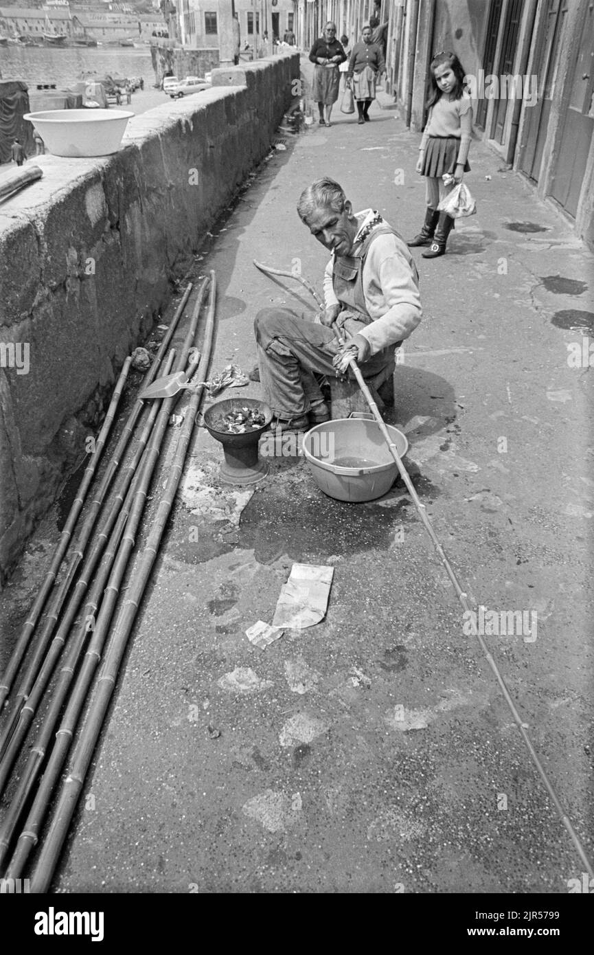PORTOGALLO - PORTO - 1970. Fare canne da pesca di bambù sul lungomare Cais da Estiva del fiume Douro nel quartiere Ribeira di Porto, P nord Foto Stock