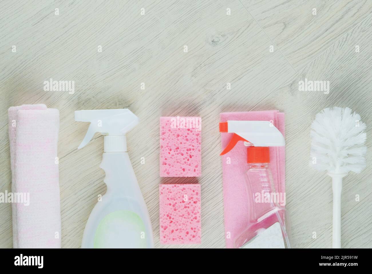 Detergenti spray. Сleaning accessori. Vista dall'alto dei materiali di pulizia rosa su sfondo di legno. Concetto di servizio. Foto Stock