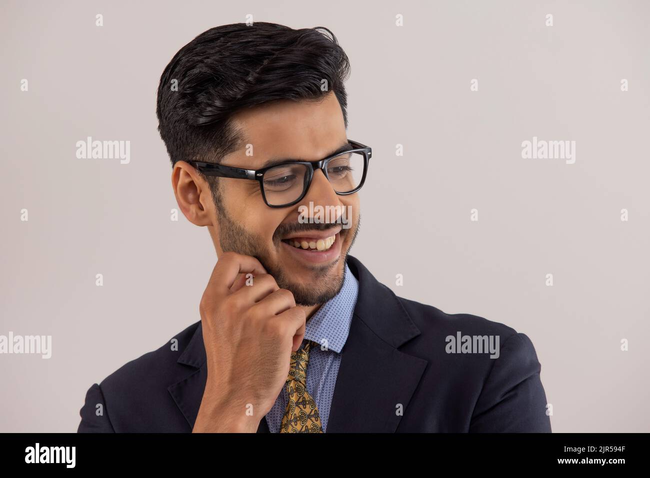 Ritratto di un dipendente aziendale in tuta aziendale formale sorridente con le mani sul viso. Foto Stock