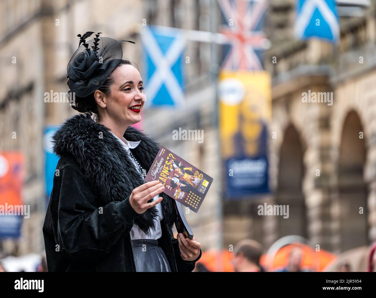 Royal Mile, Edimburgo, Scozia, Regno Unito, 22nd agosto 2022. Fringe Performers: Una donna attraente vestita in costume d'epoca mette fuori opuscoli per uno spettacolo dell'importanza di essere serio. Credit: Sally Anderson/Alamy Live News Foto Stock