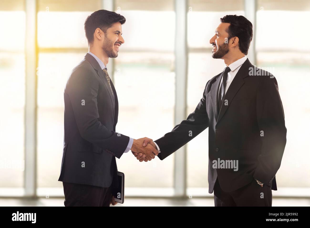 I dipendenti aziendali che lavorano in azienda si riuniscono in ufficio e si stringono le mani. Foto Stock