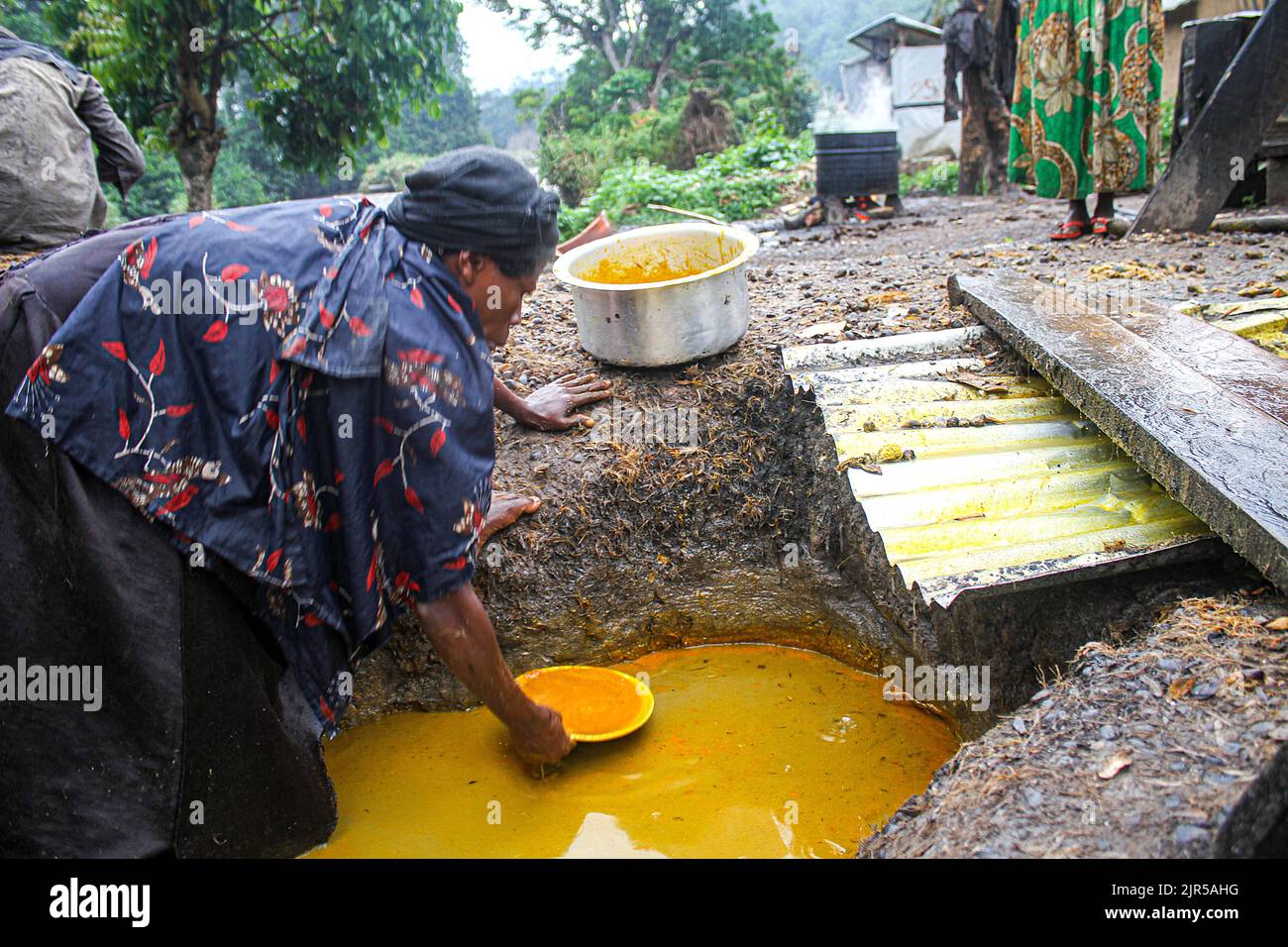 Produzione artigianale di olio di palma chiamato 'Seketa' (Stir) nella lingua locale da parte di donne del villaggio di Mpety a Walikale, Kivu Nord (RDC orientale), 15 dicembre 2021. Fabrication artisanale de l’huile de palme appelee en language locale “Seketa“ (Remuer) par des femmes du village Mpety a Walikale au Nord Kivu (Est de la RD Congo), le 15 dicembre 2021. Foto Stock
