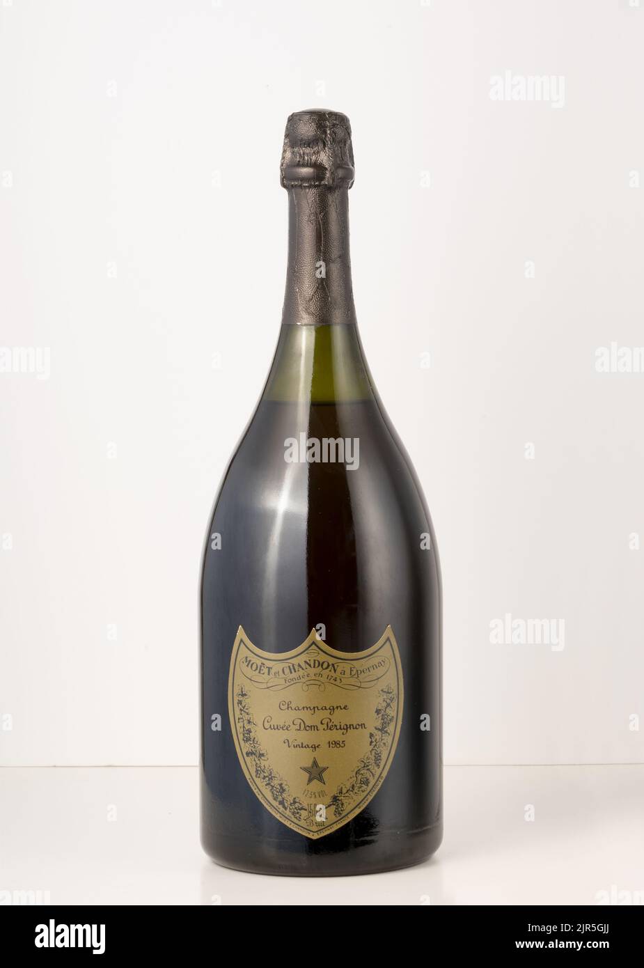 Bottiglia retrò di champagne Dom Perignon con etichetta a forma di badge posta su sfondo bianco Foto Stock
