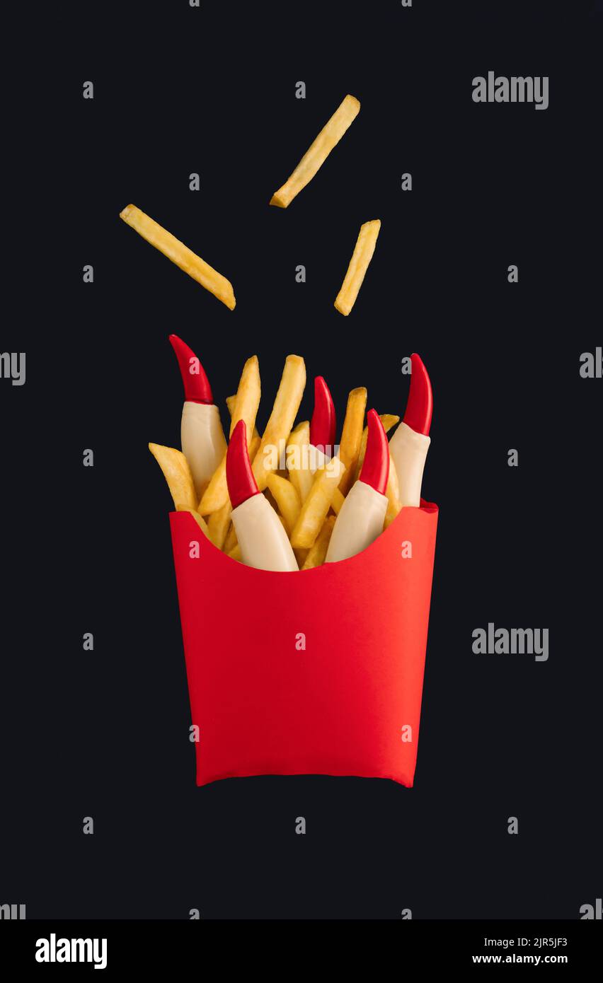 Patatine fritte con ketchup e dita di strega in scatola di carta rossa isolata su fondo nero. Horror concept di Halloween. Idea spaventosa e spoky. Foto Stock