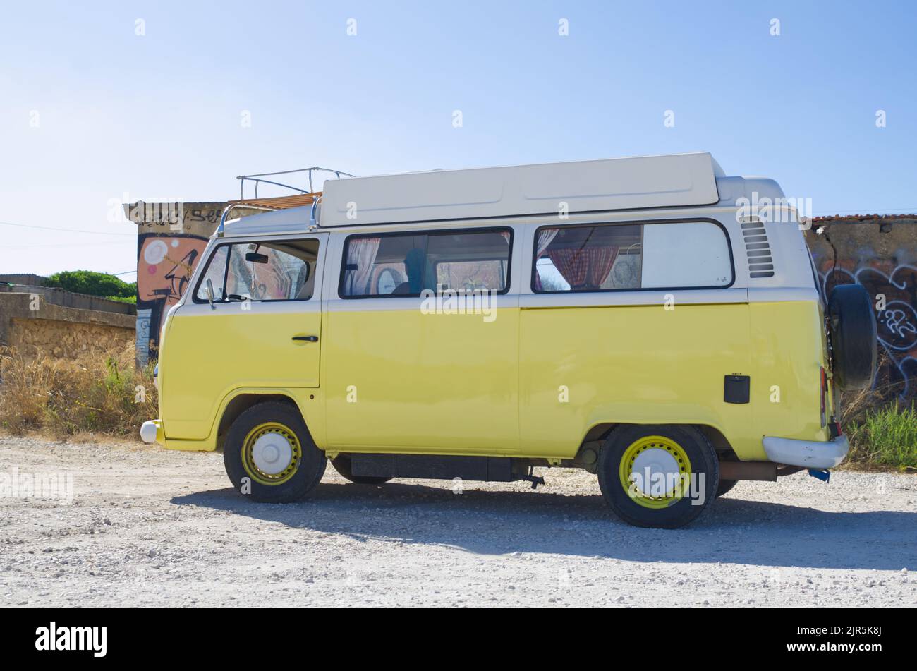 Luz, Lagos Portogallo Agosto 17 2022. T2 camper VW in giallo brillante vista laterale dettaglio in pieno sole per il noleggio Foto Stock
