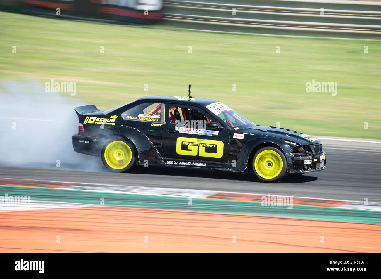 Una BMW E36 verde nero che produce fumo su un percorso di deragliamento da competizione Foto Stock