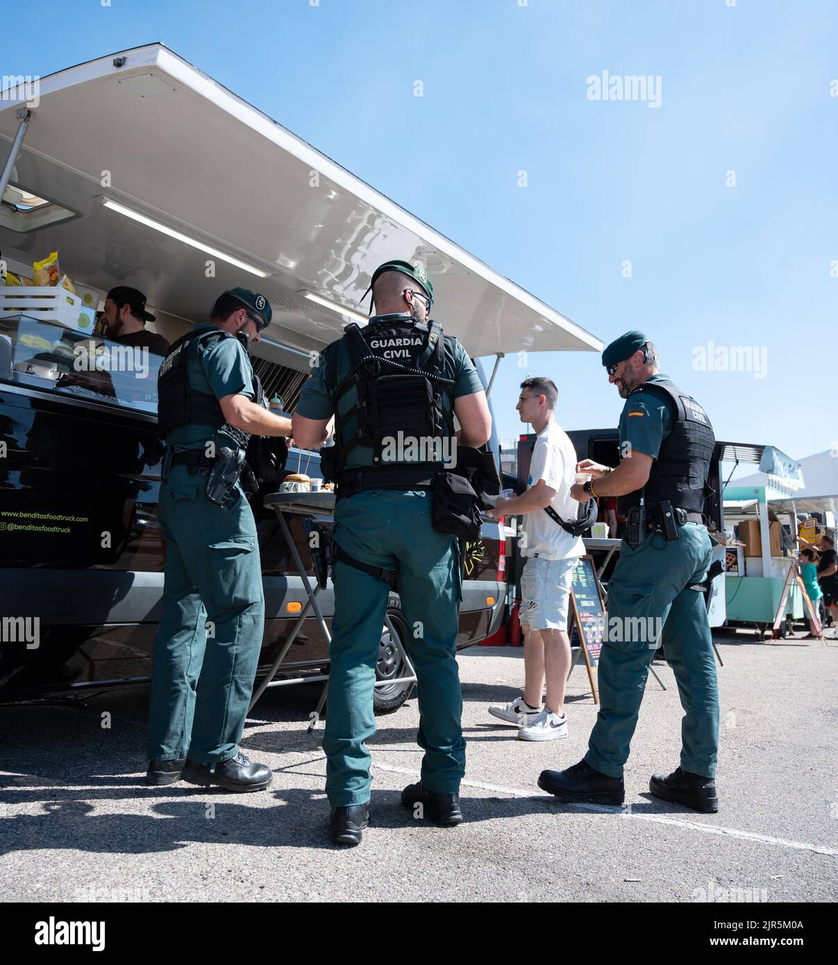 La Guardia civile spagnola mangiare da un camion alimentare in una giornata di sole Foto Stock