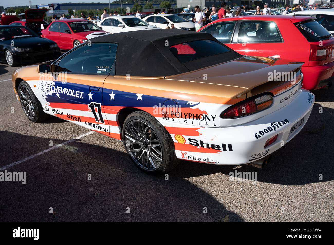 Una Chevrolet Camaro di 5th generazione in colore oro e una bandiera americana design Foto Stock