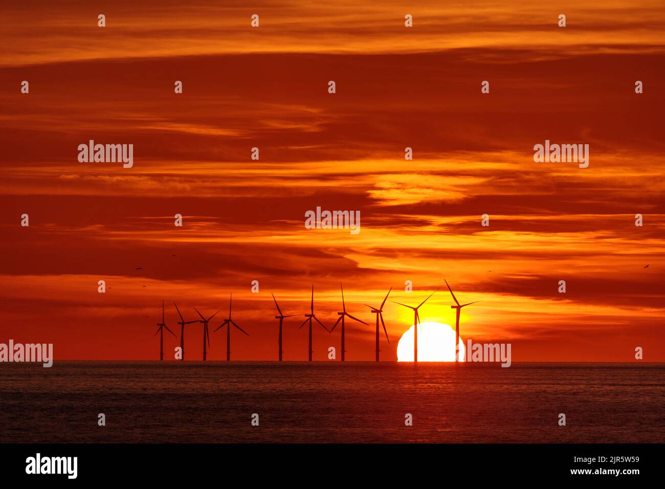Tramonto sulla fattoria eolica offshore Gwynt-y-Môr, costa del Galles del Nord Foto Stock
