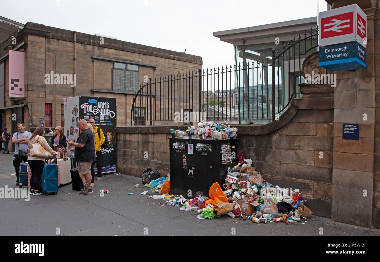Stazione di Waverley, Edimburgo, Scozia, Regno Unito. 22nd agosto 2022. È stato un peccato per arrivare in vacanza e per essere accolto da un clima noioso e arido, anche se la temperatura è di 17 gradi centigradi, ma peggio ancora sono i bidoni dei rifiuti sui marciapiedi ammassati in alto e traboccanti di rifiuti scartati subito fuori dall'entrata della stazione ferroviaria. Ciò è dovuto al fatto che gli operatori della pulizia del Consiglio della città di Edimburgo sono il quinto giorno di undici giorni di sciopero sulla retribuzione. Credit: Arch White/alamy live news. Foto Stock