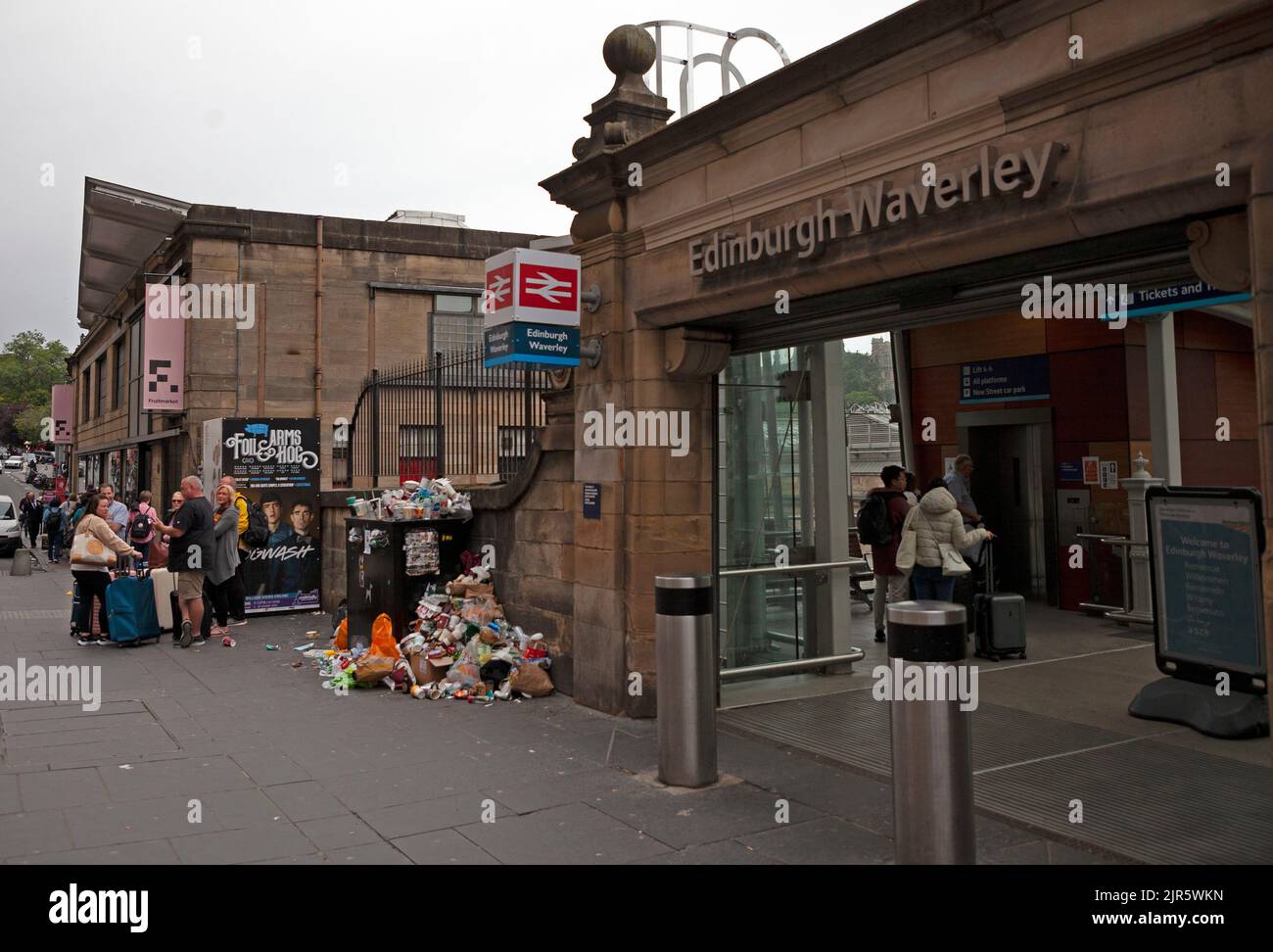 Stazione di Waverley, Edimburgo, Scozia, Regno Unito. 22nd agosto 2022. È stato un peccato per arrivare in vacanza e per essere accolto da un clima noioso e arido, anche se la temperatura è di 17 gradi centigradi, ma peggio ancora sono i bidoni dei rifiuti sui marciapiedi ammassati in alto e traboccanti di rifiuti scartati subito fuori dall'entrata della stazione ferroviaria. Ciò è dovuto al fatto che gli operatori della pulizia del Consiglio della città di Edimburgo sono il quinto giorno di undici giorni di sciopero sulla retribuzione. Credit: Arch White/alamy live news. Foto Stock
