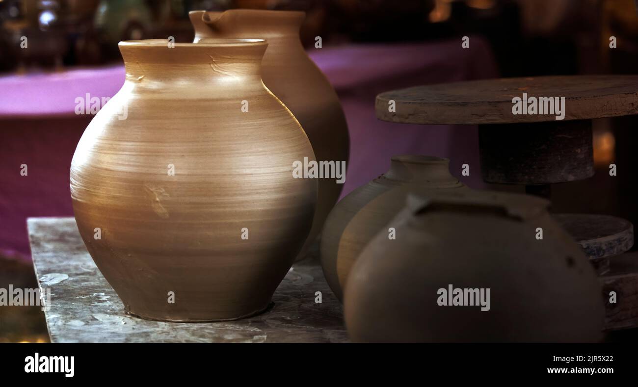 Bagnare la caraffa di argilla dopo averla processata sulla ruota del vasaio Foto Stock