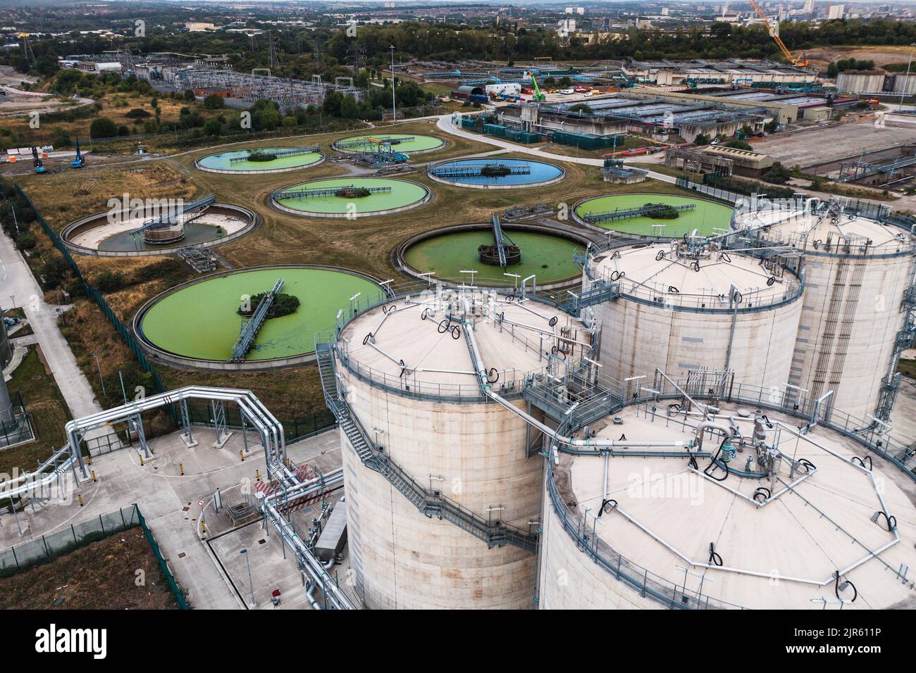 Una vista aerea direttamente sopra un trattamento delle acque reflue funziona con serbatoi di stoccaggio circolari che filtrano le acque reflue con alghe verdi per l'acqua potabile Foto Stock