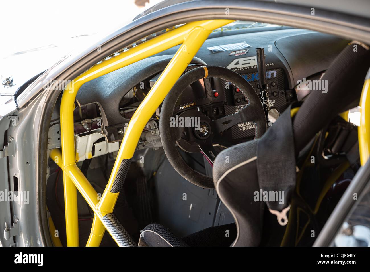 I dettagli del cockpit di un'auto da corsa drift, volante disassato, barre antirollio e freno a mano idraulico Foto Stock