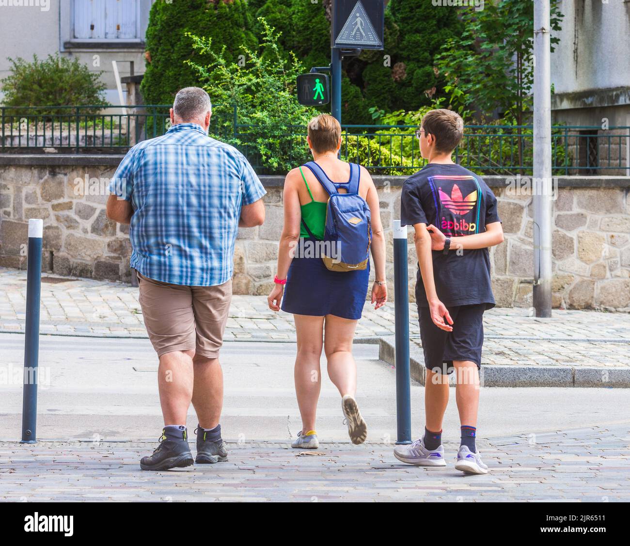 Famiglia al semaforo verde che indica sicuro per attraversare la strada - imoges, Haute-Vienne (87), Francia. Foto Stock