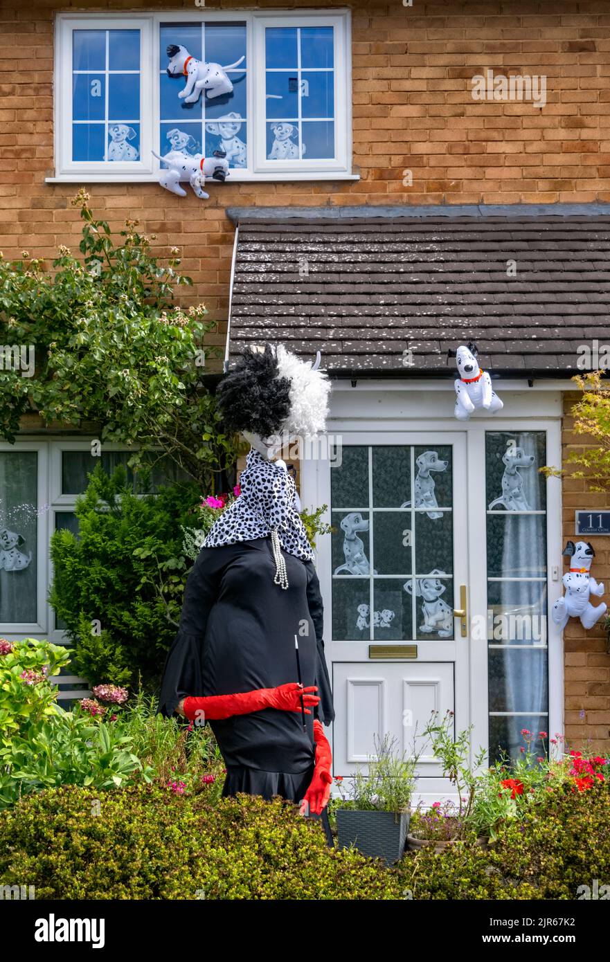 Flamstead Scarecrow Festival 2022 - Cruella de Vil e 101 Dalmatations Scarecrow e cani dalmati lamina decorare l'esterno di una casa, Flamstead. Foto Stock
