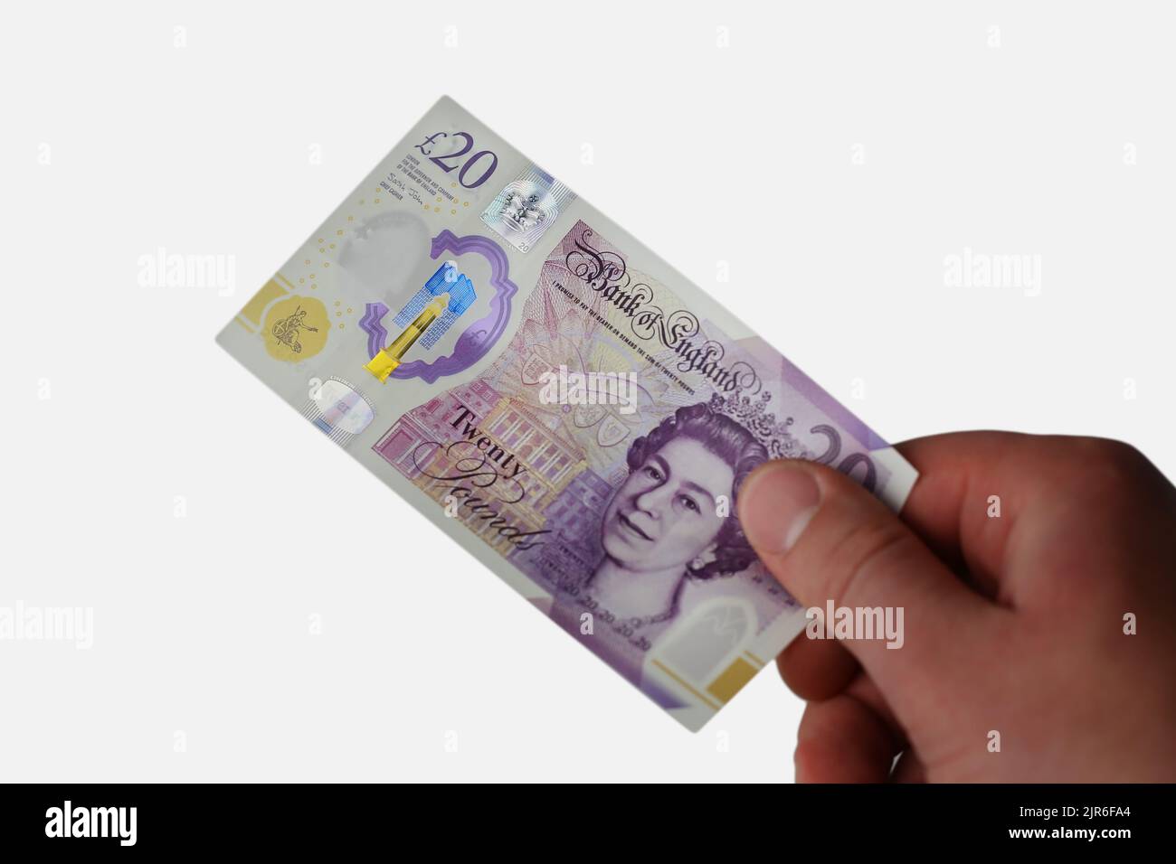 Prendere o dare un conto di 20 sterline britanniche con una mano su uno sfondo bianco isolato Foto Stock