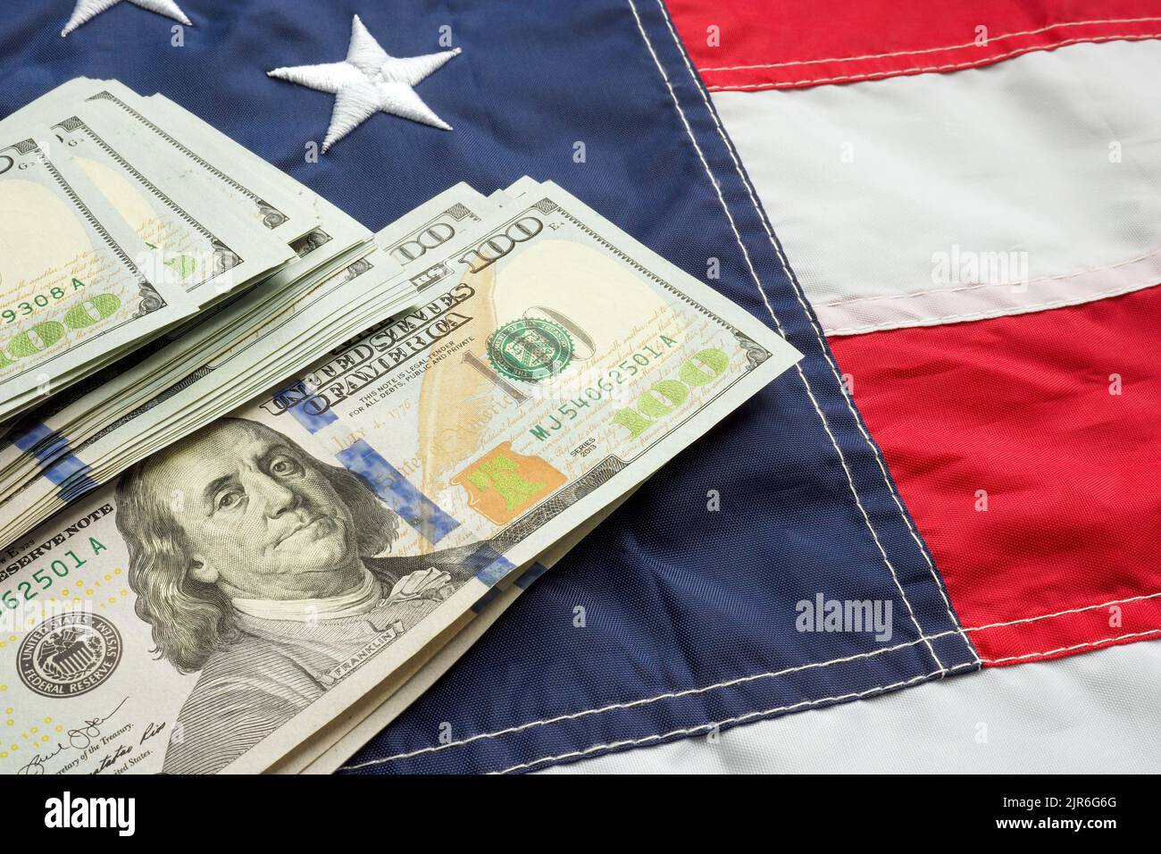 Contanti sulla bandiera degli Stati Uniti come simbolo di tasse, inflazione, il bilancio statale. Foto Stock