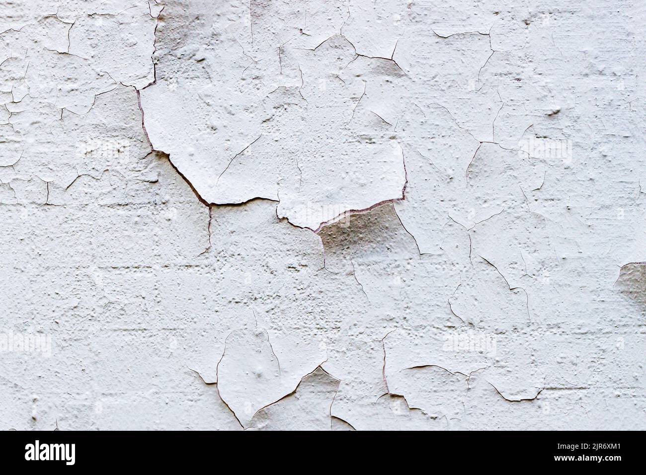 Parete con sbucciatura di vernice vecchia, residui di intonaco, colore chiaro. Sfondo Foto Stock