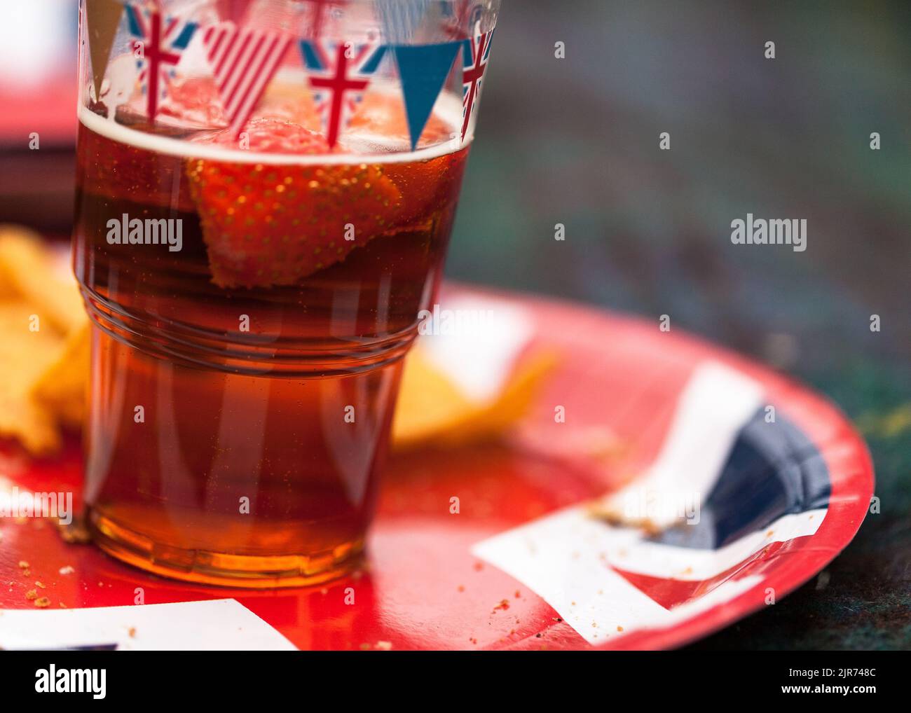 Un bicchiere di birra coperto e un piatto al picnic pomeridiano al Garth Park, Bicester Foto Stock