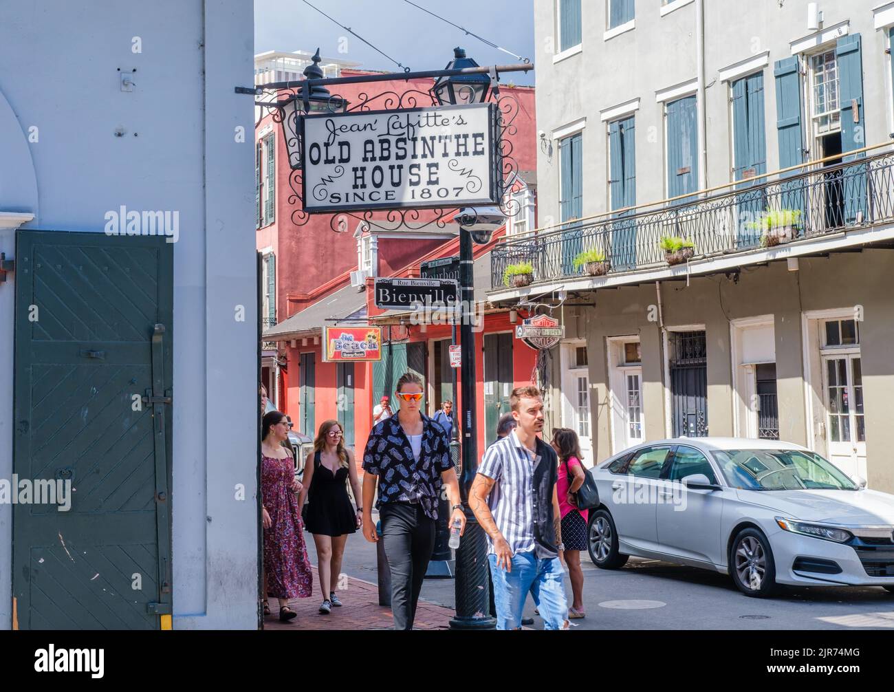 NEW ORLEANS, LA, USA - 20 AGOSTO 2022: I giovani turisti camminano vicino alla vecchia casa dell'Assenzio di Jean Lafitte all'angolo tra Bienville Street e Bourbon Street Foto Stock