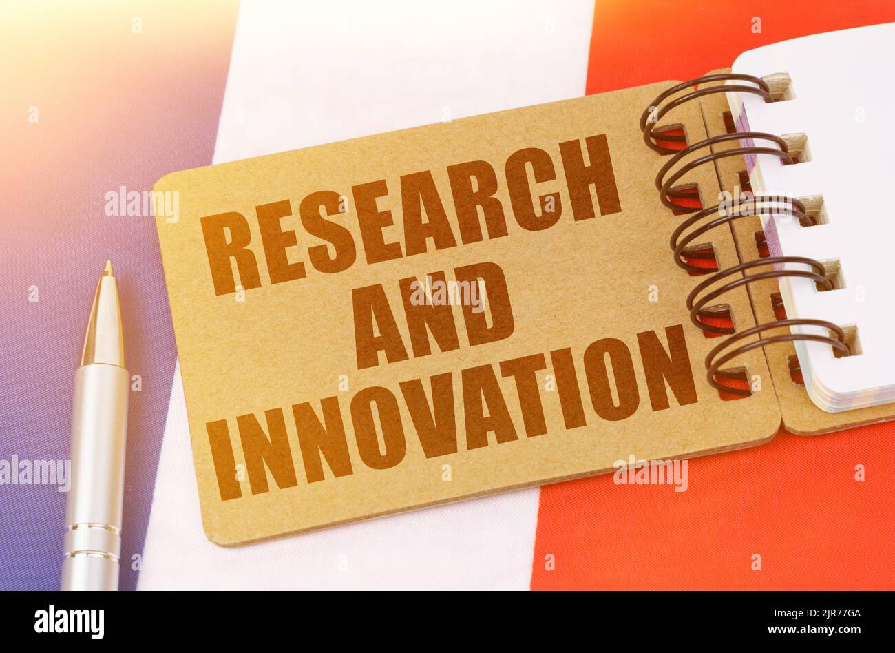 Concetto di economia nazionale. Sulla bandiera della Francia si trova un quaderno con l'iscrizione - Ricerca e innovazione Foto Stock