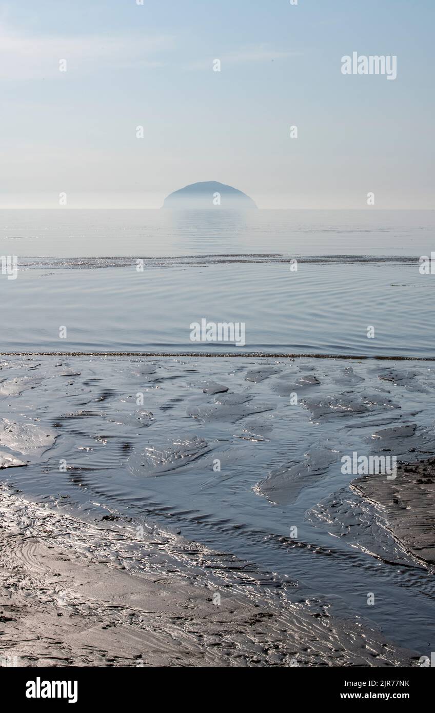 ailsa craig nel firth di clyde al largo della costa di girvan in ayrshire scozia in una mattina misty con la bassa marea. ailsa craig punto di riferimento sulla costa di ayrshire. Foto Stock