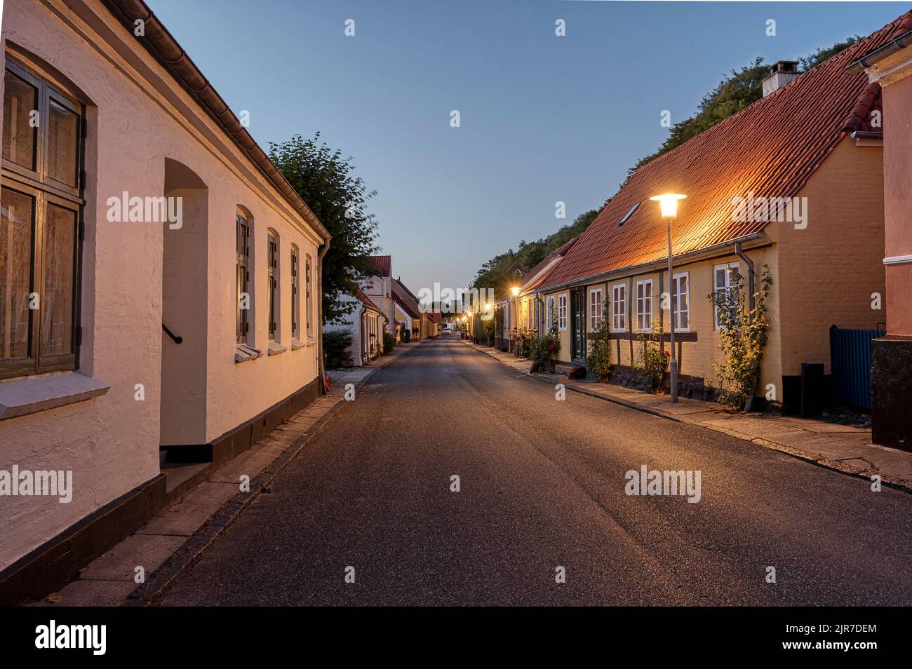 Strada lastricata con una casa a graticcio appena dopo il tramonto nella città idilliaca Mariager, Danimarca, 5 agosto 2022 Foto Stock