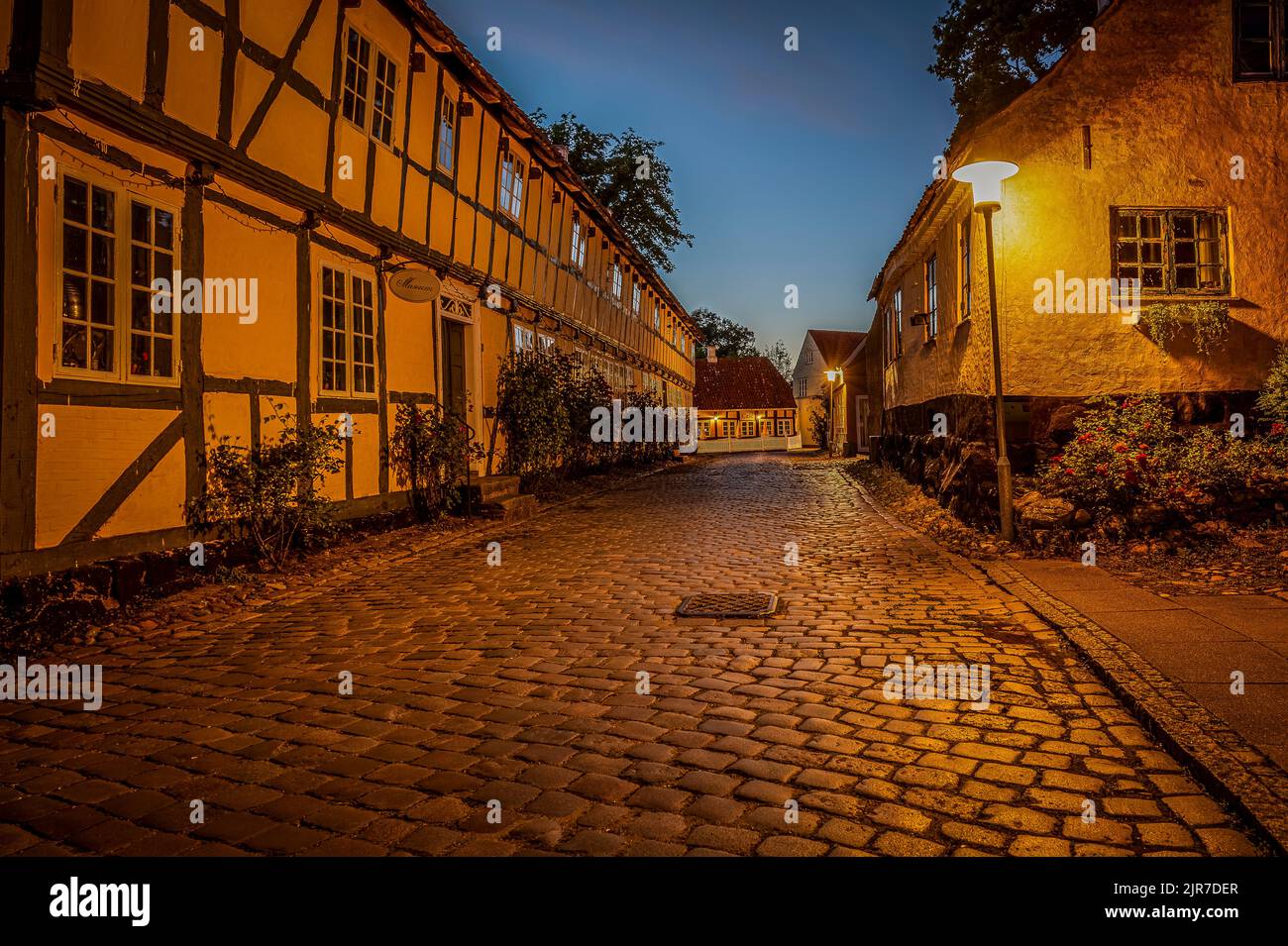 Lampione al crepuscolo nella vecchia strada acciottolata nell'idilliaca città di Mariager, Danimarca, 5 agosto 2022 Foto Stock