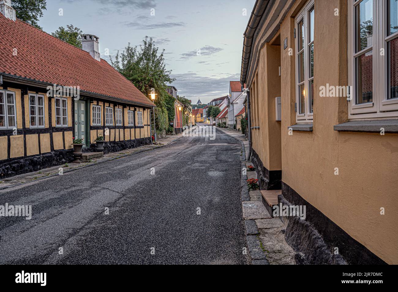 strada nella piccola città danese Mariager al tramonto, che conduce alla chiesa, Mariager, Danimarca, 7 agosto 2022 Foto Stock