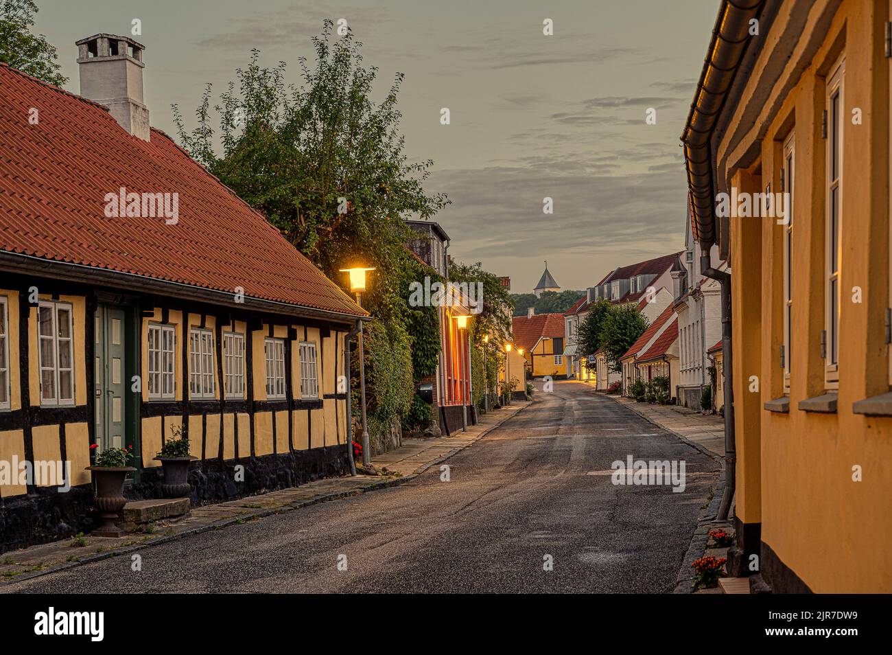 strada nella piccola città danese Mariager al tramonto, che conduce alla chiesa, Mariager, Danimarca, 7 agosto 2022 Foto Stock