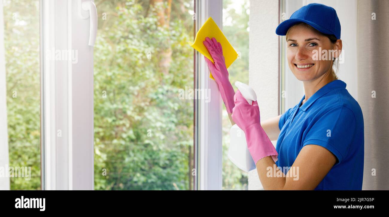 donna sorridente janitor in uniforme blu pulire una casa. servizi di pulizia. banner con spazio copia Foto Stock