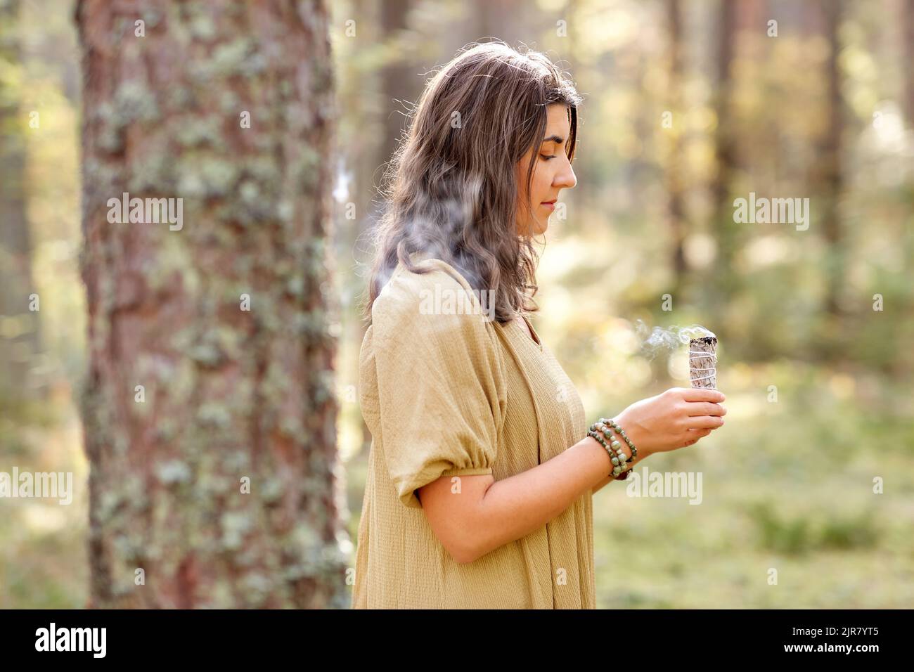 donna o strega che esegue rituale magico nella foresta Foto Stock